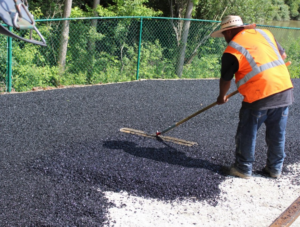 Professional installer spreading rubber surfacing.